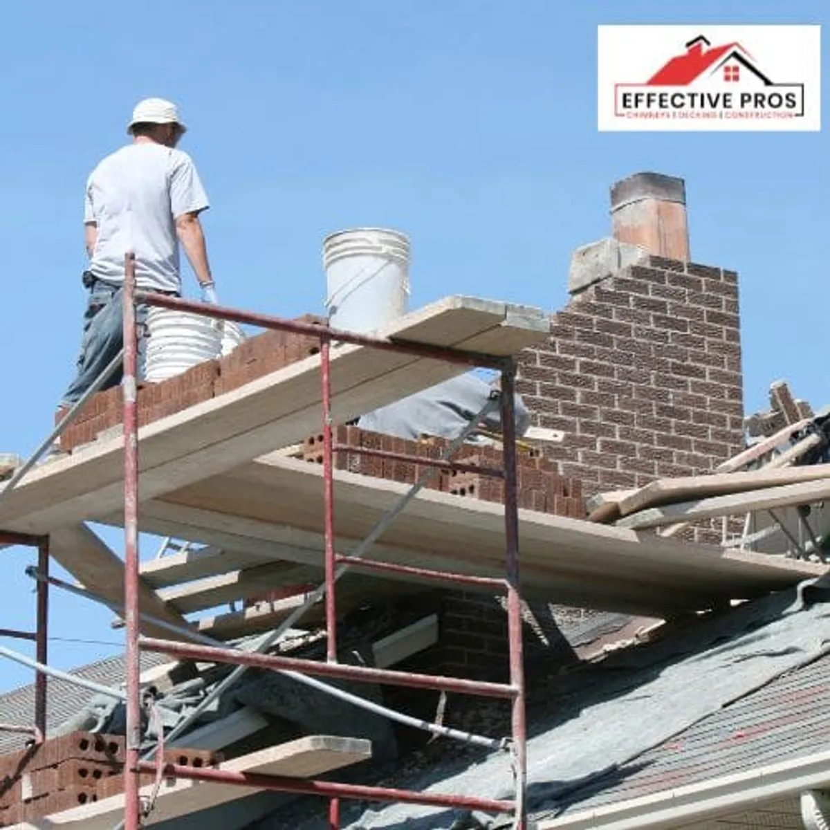 Workers and scaffolding beside a masonry chimney