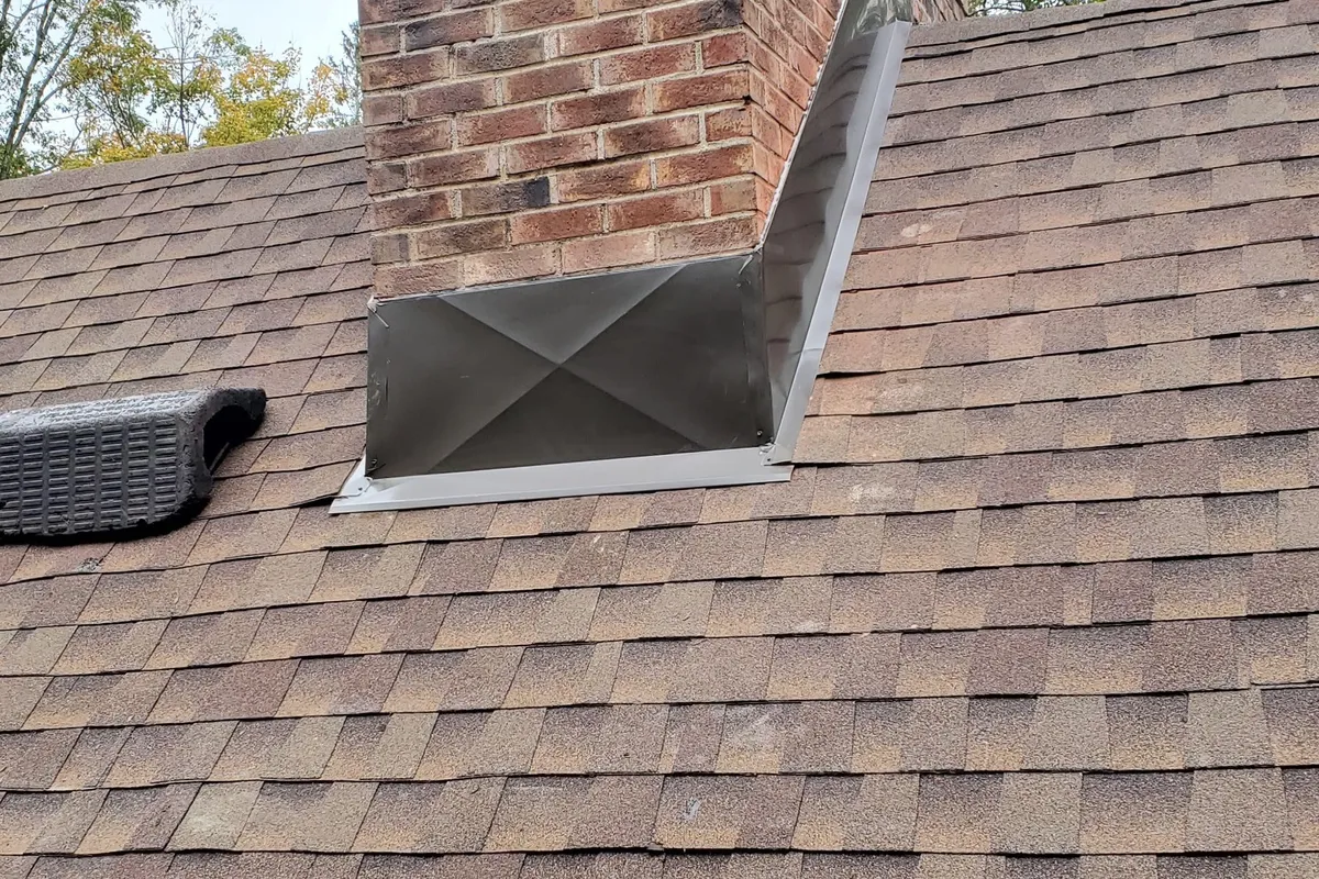 Brick chimney and flashing beside a shingle roof