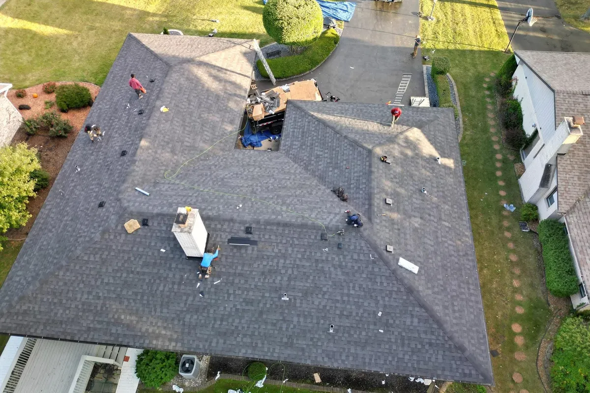 Overhead view of a shingle roof and surrounding property