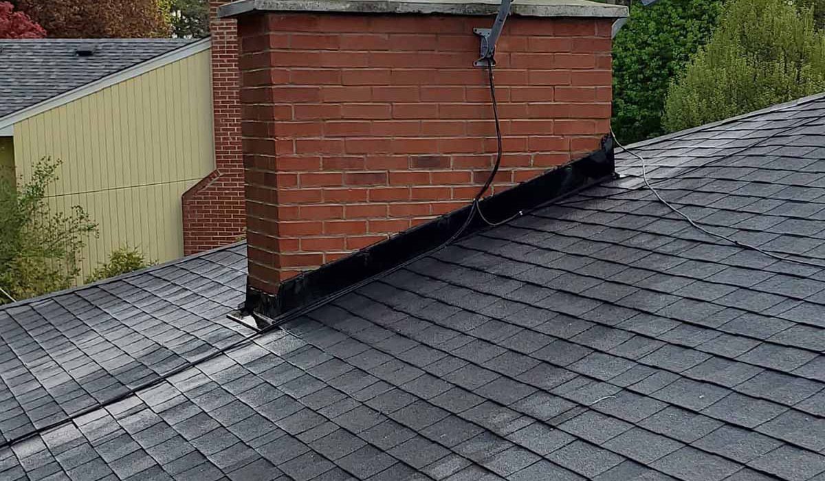 Technician sealing a leaking chimney area.