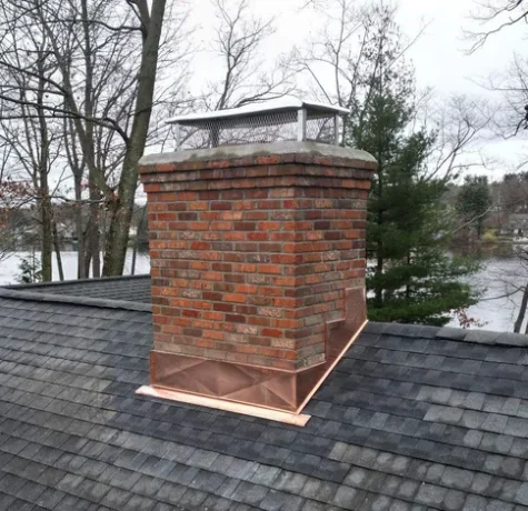 Roof flashing installed around chimney base.