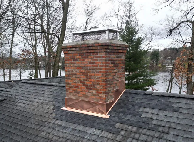 Roof flashing installed around chimney base.
