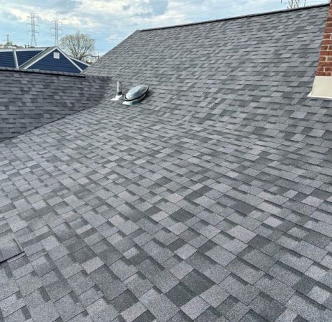 Crew installing shingles on a residential home.